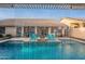 Inviting pool area with a pergola waterfall feature, comfortable seating, and a fire pit at 4637 E Fernwood Ct, Cave Creek, AZ 85331