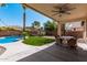 Covered backyard patio with a dining table and chairs overlooks a pool and artificial grass at 4791 S White Pl, Chandler, AZ 85249