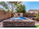 Backyard hot tub with surrounding stone detail is set against manicured desert landscaping at 4791 S White Pl, Chandler, AZ 85249