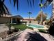 This outdoor pool is surrounded by desert landscaping with palm trees under a clear blue sky at 4791 S White Pl, Chandler, AZ 85249