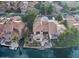 Aerial view of a lakeside home with a pool, spa, covered outdoor living room, and boat dock at 517 S Marina Dr, Gilbert, AZ 85233