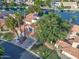 An aerial view of a lakefront home with mature trees, lush landscaping, and a well-manicured lawn at 517 S Marina Dr, Gilbert, AZ 85233
