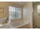 Relaxing bathtub area featuring a large soaking tub and natural light from a nearby window at 517 S Marina Dr, Gilbert, AZ 85233