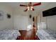 Bedroom featuring two twin beds, closet, and a television mounted to the wall at 517 S Marina Dr, Gilbert, AZ 85233