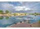 A scenic view of waterfront homes and a calm lake with a boat and dock in the foreground at 517 S Marina Dr, Gilbert, AZ 85233