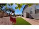 Charming backyard featuring faux grass, gravel, a flamingo lawn ornament and a brick walkway alongside the home at 522 S 122Nd Ln, Avondale, AZ 85323