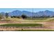 Lush golf course view featuring desert landscaping and a mountain backdrop on a clear day at 522 S 122Nd Ln, Avondale, AZ 85323