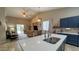 Open-concept kitchen features quartz countertops, stainless steel appliances and barstool seating at the island at 522 S 122Nd Ln, Avondale, AZ 85323