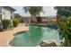 Backyard swimming pool with desert landscaping, rock waterfall feature, and patio seating at 522 S 122Nd Ln, Avondale, AZ 85323