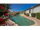 Backyard pool with desert landscaping, rock features, and adjacent brick patio at 522 S 122Nd Ln, Avondale, AZ 85323