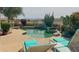 Backyard swimming pool surrounded by desert landscaping, lounge chairs, and golf course views at 522 S 122Nd Ln, Avondale, AZ 85323