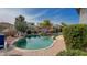 Backyard pool area with desert landscaping, rock features, and views of neighboring homes at 522 S 122Nd Ln, Avondale, AZ 85323