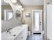 Bright bathroom with long double vanity, round mirror, and outdoor access to the backyard at 5532 W Onyx Ave, Glendale, AZ 85302