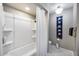 Clean bathroom featuring a shower-tub combo, neutral tones, and patterned flooring at 5532 W Onyx Ave, Glendale, AZ 85302