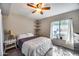 Cozy bedroom features carpet, a ceiling fan, corner shelves, and a window providing natural light at 5532 W Onyx Ave, Glendale, AZ 85302