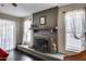 Cozy living room featuring a stone fireplace, windows with sheer curtains, and a rocking chair at 5532 W Onyx Ave, Glendale, AZ 85302