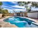 Backyard swimming pool with clear blue water reflects the sky near covered patio and landscaping at 5532 W Onyx Ave, Glendale, AZ 85302