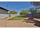 Well-maintained backyard with fresh green lawn, desert flora, patio lights, brick pavers, and secure perimeter fence at 6071 E Ludlow Dr, Scottsdale, AZ 85254