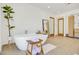 Elegant bathroom featuring a freestanding tub, potted plant, and light tile flooring at 6071 E Ludlow Dr, Scottsdale, AZ 85254