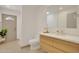 Modern bathroom with a sleek vanity, toilet, and tiled floors leading to an exterior door at 6071 E Ludlow Dr, Scottsdale, AZ 85254