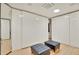 Luxurious walk-in closet featuring custom built-ins and a pair of black cushioned ottomans for added comfort and style at 6071 E Ludlow Dr, Scottsdale, AZ 85254