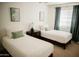 Bright bedroom features twin beds, a nightstand and neutral walls at 7023 E 4Th St # 104, Scottsdale, AZ 85251