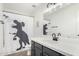 Bathroom featuring white vanity, dark hardware, and shower curtain with fun dinosaur design at 807 E Harvard Ave, Gilbert, AZ 85234