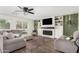 Cozy living room featuring a fireplace, built-in shelving, a ceiling fan, and wood-look floors at 807 E Harvard Ave, Gilbert, AZ 85234