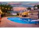 Backyard view of the inground pool, diving board, slide and string lights at dusk at 8432 E Redwing Rd, Scottsdale, AZ 85250