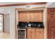 Small bar area featuring wood cabinets, a wine cooler, and granite countertops at 8749 E Via De Sereno --, Scottsdale, AZ 85258