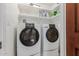 A laundry room with white washer and dryer units and ample shelving space at 8749 E Via De Sereno --, Scottsdale, AZ 85258