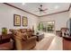 Inviting living room featuring a comfortable brown sofa, ceiling fan, and sliding doors to the outdoor patio at 8749 E Via De Sereno --, Scottsdale, AZ 85258