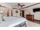 A well-lit main bedroom featuring wood floors, a ceiling fan, and an en suite bathroom at 8749 E Via De Sereno --, Scottsdale, AZ 85258