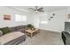 Carpeted living room with ceiling fan, couch, coffee table, and decor at 9208 W Coolidge St, Phoenix, AZ 85037