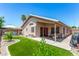Cozy backyard featuring manicured landscaping, artificial grass, a seating area and covered patio at 9853 W Tonopah Dr, Peoria, AZ 85382