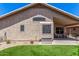 Backyard featuring artificial turf, gravel landscaping, a covered patio, and the exterior of the property at 9853 W Tonopah Dr, Peoria, AZ 85382