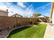 Spacious backyard with artificial turf, rock landscaping, privacy wall and covered seating area at 9853 W Tonopah Dr, Peoria, AZ 85382