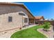 Backyard with lush artificial turf, gravel landscaping, covered patio area, and well-maintained exterior of the home at 9853 W Tonopah Dr, Peoria, AZ 85382