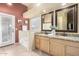 Bright bathroom with a double vanity, framed mirrors, a soaking tub, and a door to the outside at 9853 W Tonopah Dr, Peoria, AZ 85382