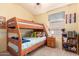 bedroom features a bunk bed, side table, and bookshelf in a bright, inviting space at 9853 W Tonopah Dr, Peoria, AZ 85382