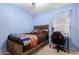 Light blue bedroom with comfortable bed, desk with chair, and natural light at 9853 W Tonopah Dr, Peoria, AZ 85382