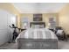 Large bedroom with a king bed dressed in striped bedding, framed by bedside tables and exercise bike in the corner at 9853 W Tonopah Dr, Peoria, AZ 85382