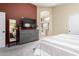Well-lit bedroom with a dresser and mirror, and a doorway leading to an adjacent bathroom with a tub at 9853 W Tonopah Dr, Peoria, AZ 85382
