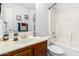 Bright bathroom features a white tiled shower-tub, white toilet, and wood vanity with a neutral countertop at 10510 W Louise Dr, Peoria, AZ 85383