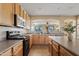 Traditional kitchen with stainless appliances, wood cabinetry, and an open view of the dining area at 11405 E Rafael Ave, Mesa, AZ 85212