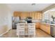 Traditional eat-in kitchen features stainless steel appliances, center island with seating, and wood cabinetry at 11405 E Rafael Ave, Mesa, AZ 85212