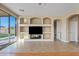 Bright living room featuring hardwood floors, custom built-ins, and sliding glass door to patio at 11405 E Rafael Ave, Mesa, AZ 85212