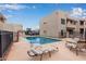 Community pool area with lounge chairs and a covered parking area at 11666 N 28Th Dr # 234, Phoenix, AZ 85029