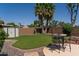 A spacious backyard featuring a storage shed, dining table and manicured lawn, surrounded by stone landscaping at 1213 N Raven --, Mesa, AZ 85207