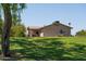 Warm tan home featuring a covered patio, complemented by a lush green lawn at 1213 N Raven --, Mesa, AZ 85207